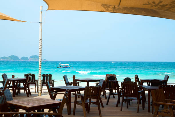 istock Empty wooden restaurant tables facing beautiful tropical ocean view 2169966018