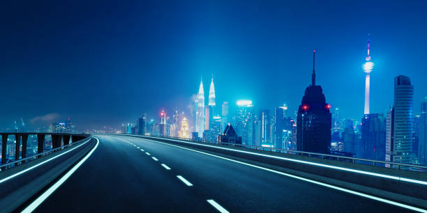 istock Empty highway road leading to illuminated kuala lumpur skyline at night 2169966077