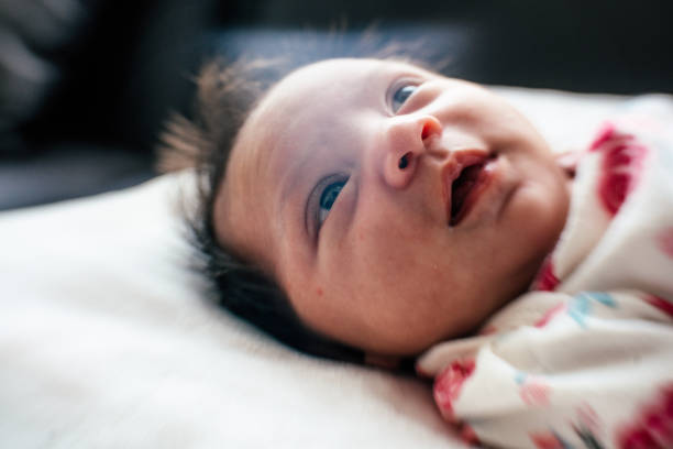 Cute newborn baby girl looking at camera