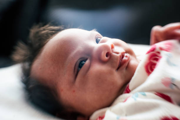 Cute newborn baby girl looking at camera