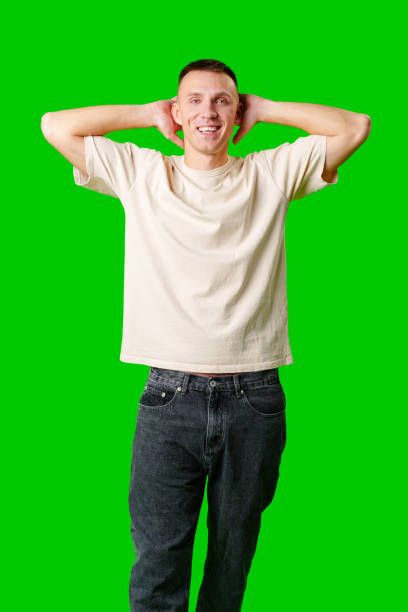 Man Reacting in Surprise With Hands on Head Against a Bright Green Background
