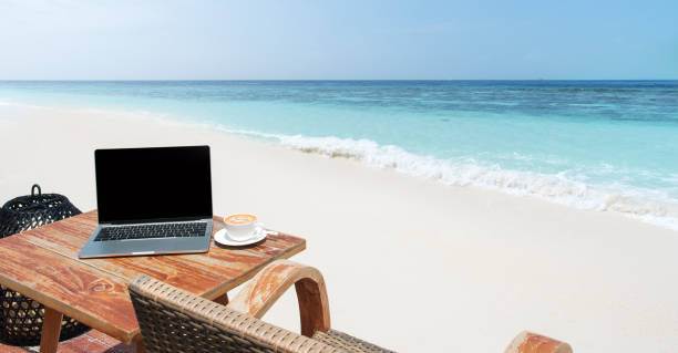 istock Mobile work office on the tropical beach with blank laptop screen 2169973938