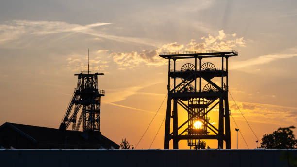 Two old winding towers of an underground coal mine at sunrise