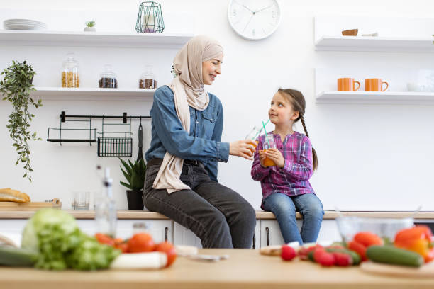 istock Mother and daughter drinking juice in modern kitchen 2169975081