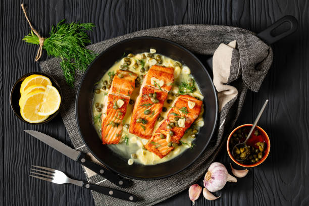 salmon piccata with lemon caper sauce in a pan