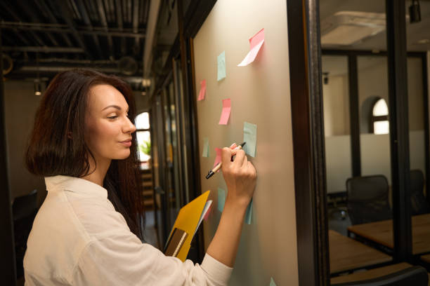 istock Young office employee takes notes on colorful stickers 2169976612