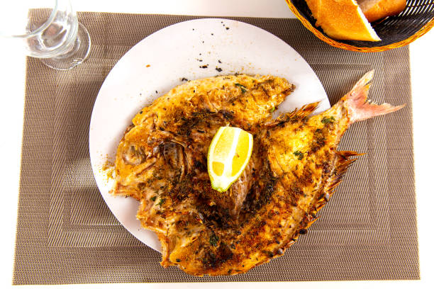 Dorado fish with lemon served at plate closeup