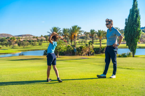 istock Golf instructor teaching hot to play to a boy 2169979206