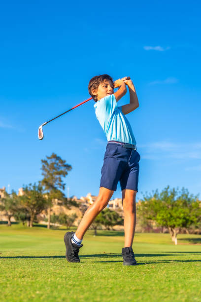 istock Boy swinging golf against blue sky in a green course 2169979227
