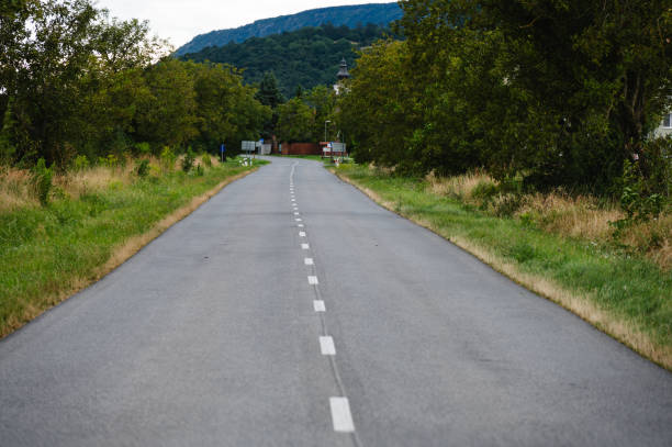 istock empty rural road leading towards village and hills 2169979829