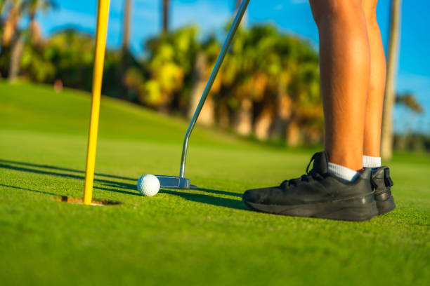 istock Person putting golf ball in a green course 2169979888