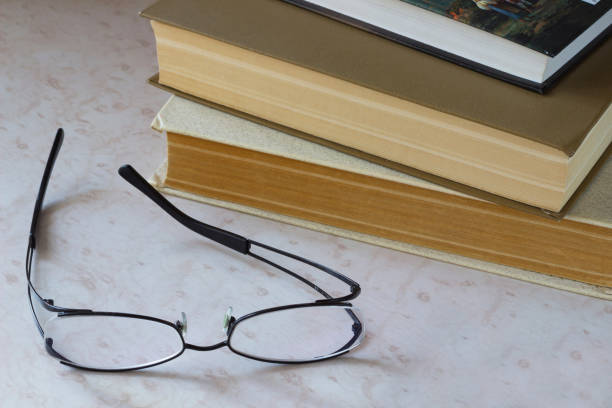 Phone. Glasses and old books on the desktop