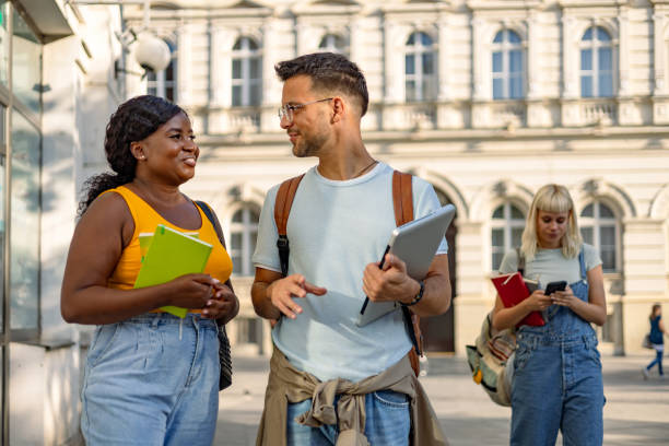 istock Friends conversing outdoors, two hugging in street 2169984788