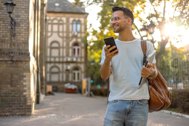 istock Young man with backpack looking at phone on campus 2169985280