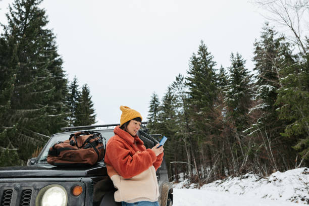 istock An Asian woman using mobile phone on a winter road trip 2169986343
