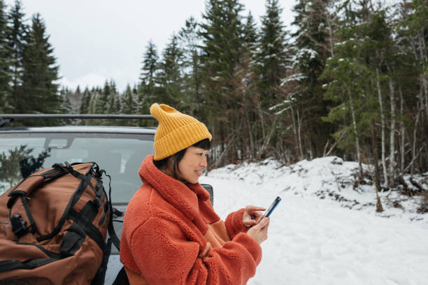 istock An Asian woman using mobile phone on a winter road trip 2169986349