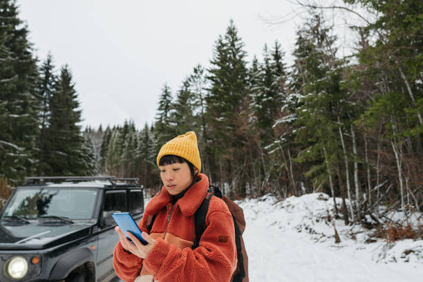 istock An Asian woman using mobile phone on a winter road trip 2169986358