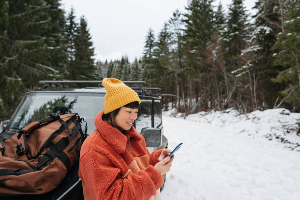 istock An Asian woman using mobile phone on a winter road trip 2169986364