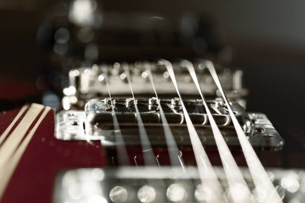 A classic electric guitar with a sunburst finish is placed on a wooden surface, showcasing its intricate design and hardware. The warm colors enhance its vintage appeal.