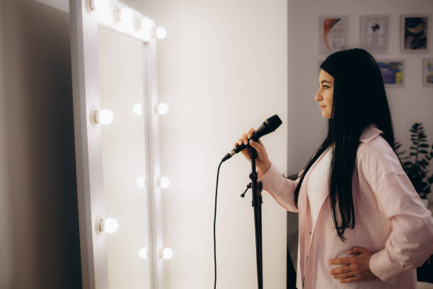 istock A woman sings into a microphone in front of a mirror 2169987668