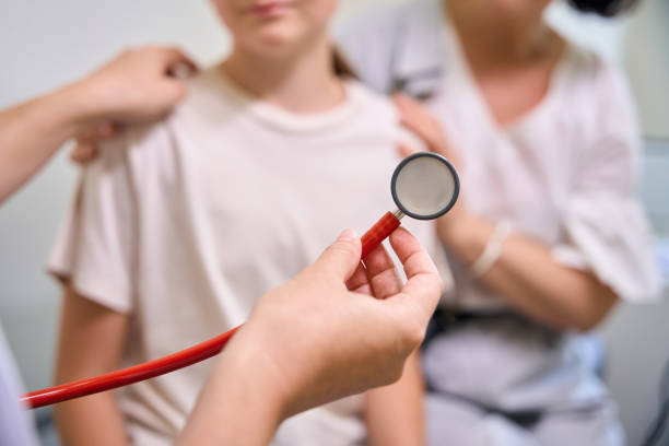 The head of a medical stethoscope in a hand, close-up, isolated on a white background. Medical diagnosis concept. Pulse measurement, hospitalization