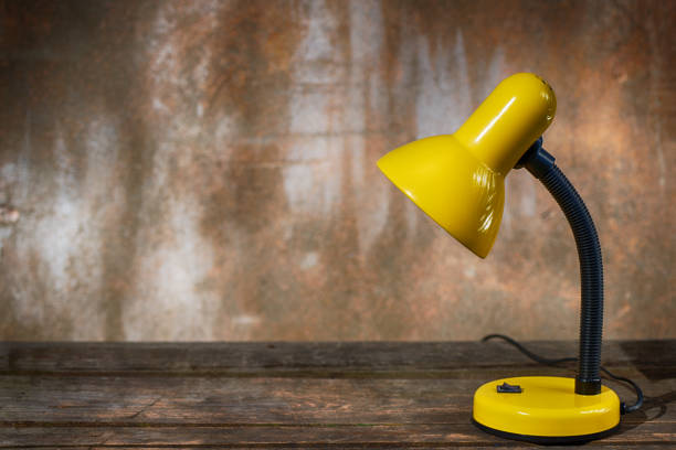 A table lamp on an old wooden table against a shabby background
