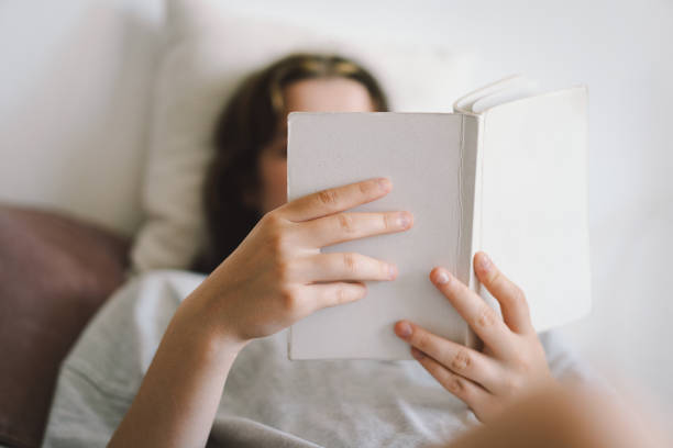 istock A woman relaxes on a couch and reads a book 2169989585