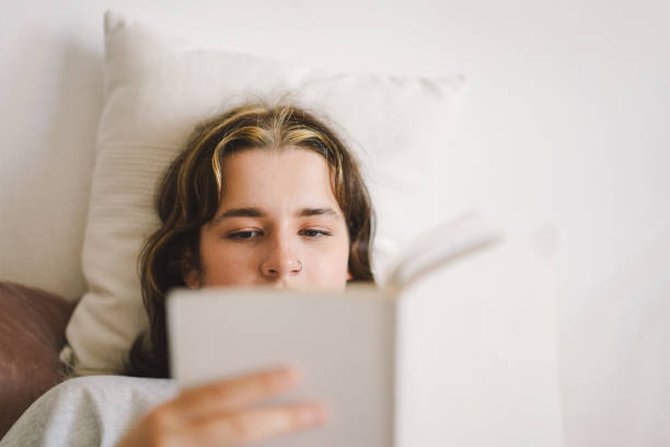 istock A woman relaxes on a couch and reads a book 2169989623