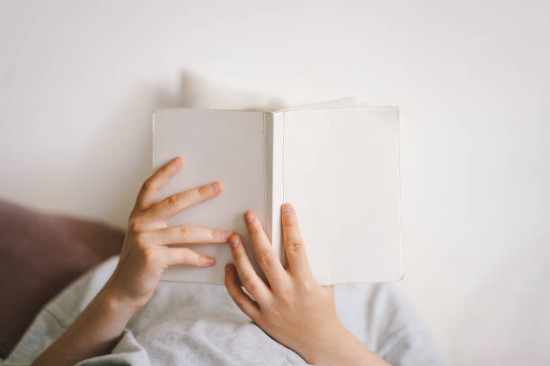 istock A woman relaxes on a couch and reads a book 2169989635