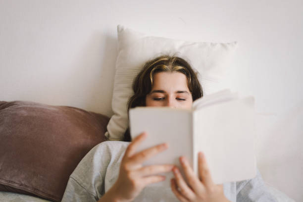 istock A woman relaxes on a couch and reads a book 2169989659