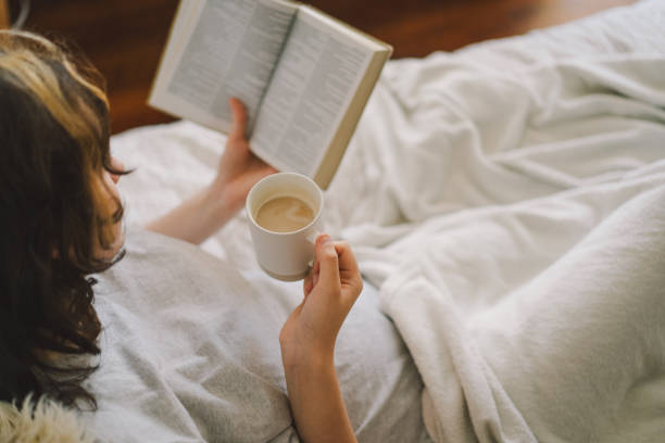istock A woman relaxes on a couch and reads a book 2169989690