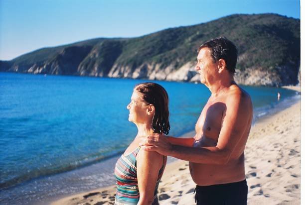 Senior couple enjoying sunrise on a beach vacation. Active seniors. Shoot on film.