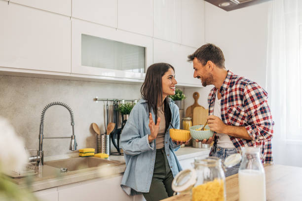 istock young cheerful couple eating cornflakes for breakfast in kitchen 2169990558