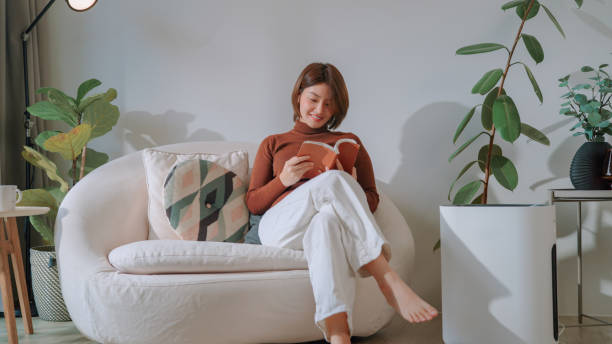 istock Asian woman reading a book at home 2169995686