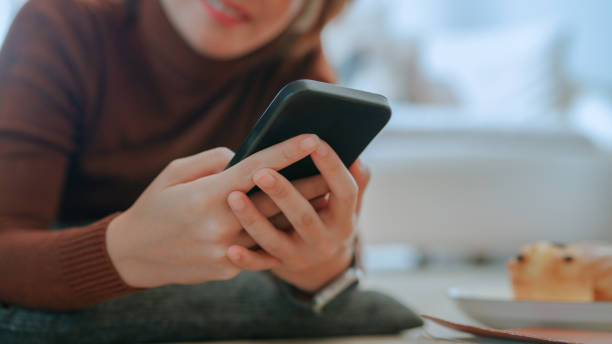 istock Asian woman using phone in living room 2169996252