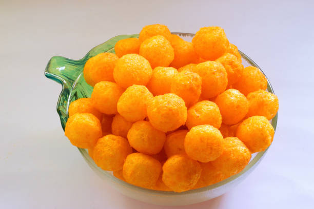 istock Cheeseballs in a carved glass bowl isolated against plain background. 2169999303