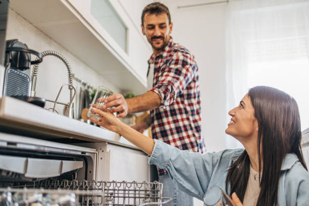 istock Young cheerful couple loading the dishwasher in the kitchen. 2170010352