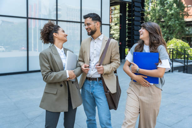 istock Three diverse business people working and talking focused and thoughtful seriously outside office building, male and female, discussing plans and work project. Businessman and businesswoman teamwork. 2170011333