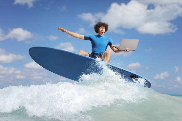 istock Man in a wetsuit surfing with a laptop 2170013493