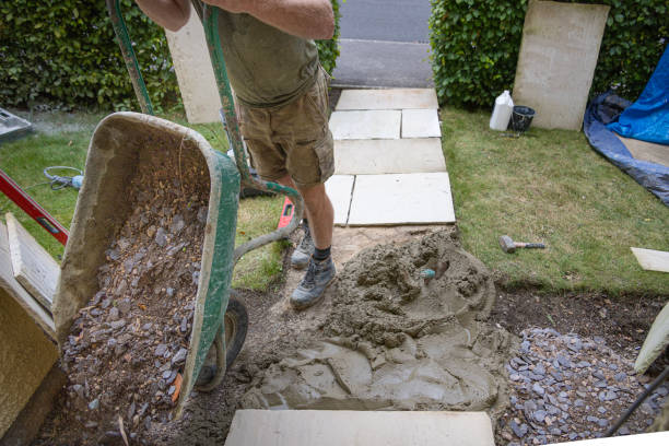 istock Tradesman laying down a hardcore base in preparation to lay down stone slabs as he constructs a new stone pathway to a residential house. 2170015554