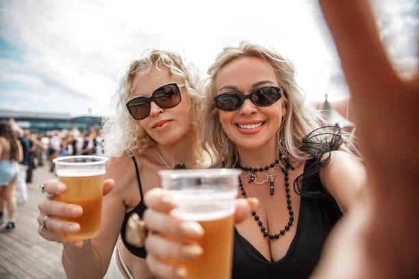 Two beautiful senior female friends enjoying downtime together at a daytime dance event