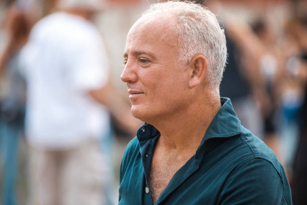A handsome senior man enjoying downtime at a daytime dance event