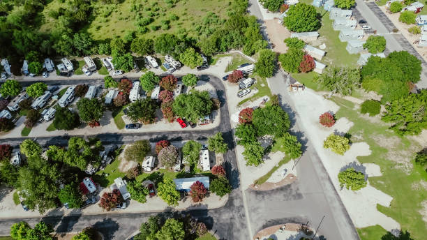 Full hookup RV site, vacation rentals in New Braunfels, Texas Hill Country, concrete patio, gravel pads for slide-outs, pull-through, back-in recreational vehicles in lush green tree area, aerial. USA sitio de rv de conexión completa, alquileres vacacionales en new braunfels, texas hill country, patio de concreto, almohadillas de grava para deslizamientos, vehículos recreativos de estacionamiento, vehículos recreativos de respaldo en una exuberante �