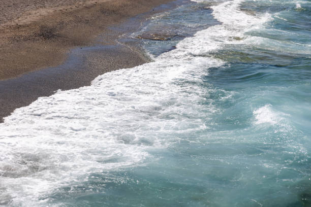 Shore water with waves and white foam. Mahmutlar beach, Turkey