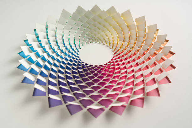 Intricately woven paper sculpture with vibrant gradient colors forming a dynamic, circular pattern on a clean white background.