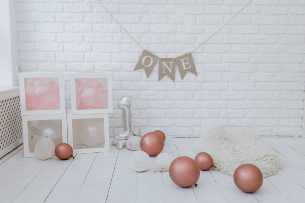 Bright photo studio with balloons, 1 year old ballon, on the white bricks wall
