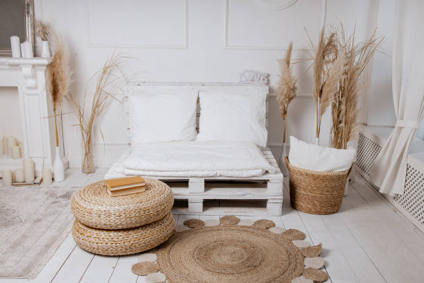 istock Bright studio in boho style, white sofa, wicker table, carpet, basket, white fireplace with candles 2170025396