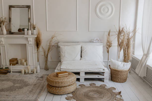 istock Bright studio in boho style, white sofa, wicker table, carpet, basket, white fireplace with candles 2170025398