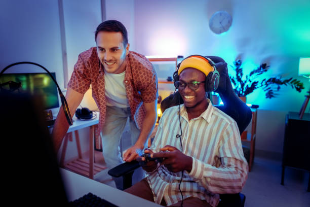 istock Friends having fun while playing video game at the neon lighted apartment room 2170026313