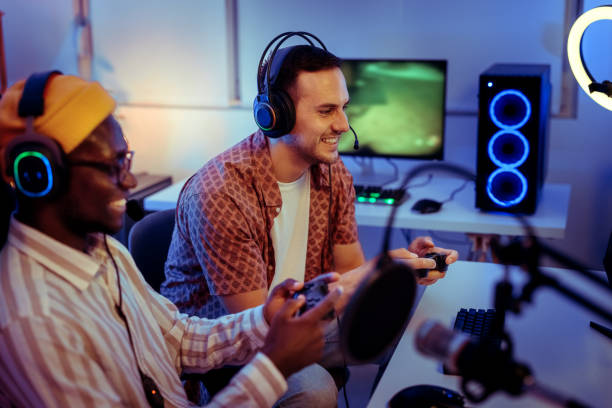 istock Two friends playing video games together on desktop PC in neon lighted room 2170026339